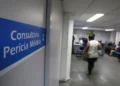 Sala de perícia médica do INSS com placa indicando consultório e atendimento aos segurados.