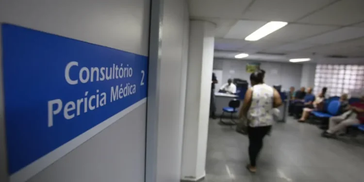 Sala de perícia médica do INSS com placa indicando consultório e atendimento aos segurados.