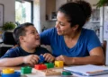 Mãe brasileira interagindo com filho com deficiência durante momento de cuidado familiar, representando o projeto de criação do Auxílio Mãe Atípica.