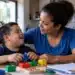 R$ 600 + R$ 150 por dependente: entenda o projeto que cria auxílio para mães atípicas 14 Mãe brasileira interagindo com filho com deficiência durante momento de cuidado familiar, representando o projeto de criação do Auxílio Mãe Atípica.