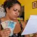 Mães de Pernambuco: veja as próximas datas de pagamento do benefício de R$ 300 em 2026 14 Mulher confere calendário e segura dinheiro, representando as próximas datas de pagamento do Mães de Pernambuco em 2026.