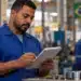 Fim da escala 6x1: veja como será feito o cálculo das horas de trabalho 14 Trabalhador de uniforme azul registra informações em uma prancheta dentro de uma fábrica, representando o controle das horas de trabalho com o fim da escala 6x1.