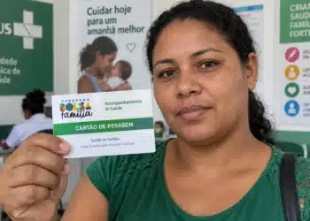 Cartão de pesagem do Bolsa Família: famílias precisam retirar o documento e manter as informações em dia 5 Mulher segura cartão de pesagem do Bolsa Família em uma unidade de saúde.