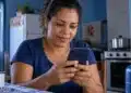 App Meu Social mostra se a família tem vale do Gás do Povo e onde fica a revenda credenciada mais perto 14 Mulher consulta o celular, representando a busca por informações sobre o vale do Gás do Povo pelo app Meu Social.