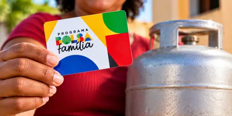 Beneficiária segura cartão do Bolsa Família ao lado de botijão de gás