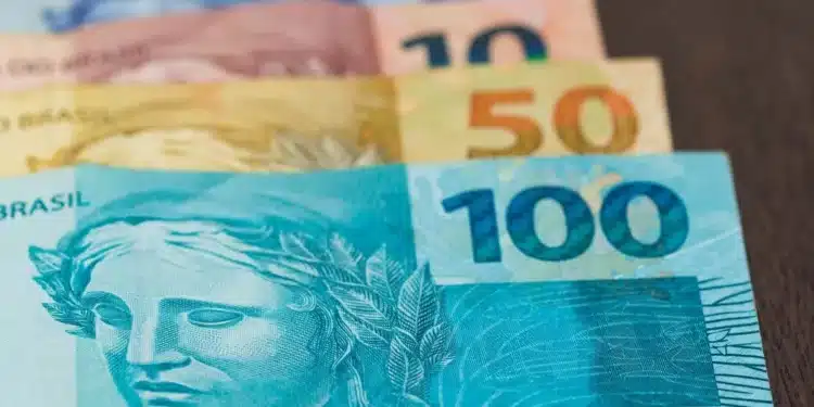 Cédulas de real brasileiro de diferentes valores representam o pagamento antecipado do décimo terceiro salário de 2026 aos trabalhadores com carteira assinada.