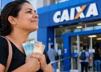 Caixa amplia o Saque Calamidade do FGTS a partir desta sexta (23/10); confira as cidades incluídas 6 Mulher segura notas de reais em frente a uma agência da Caixa Econômica Federal, ilustrando a ampliação do Saque Calamidade do FGTS em outubro de 2026.