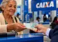 Idosa recebe dinheiro em agência da Caixa Econômica Federal, representando o pagamento do BPC de outubro de 2026.