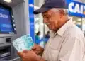 BPC de outubro começa a ser pago pelo INSS: confira quem recebe de 26 a 30/10 por final do benefício 14 Idoso sacando pagamento em caixa eletrônico da Caixa, representando o pagamento do BPC de outubro.