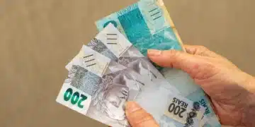 Mãos seguram cédulas de reais, ilustrando a liberação do Saque Calamidade do FGTS para trabalhadores de novos municípios em 8 de outubro.
